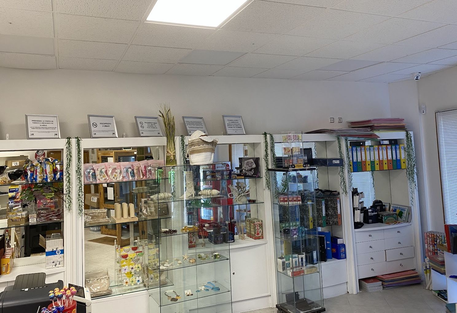 Vitrinas blancas con regalos, decoración y artículos de papelería dentro del estanco